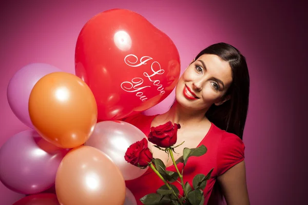 Belle femme avec des décorations de la Saint-Valentin sur fond rose — Photo