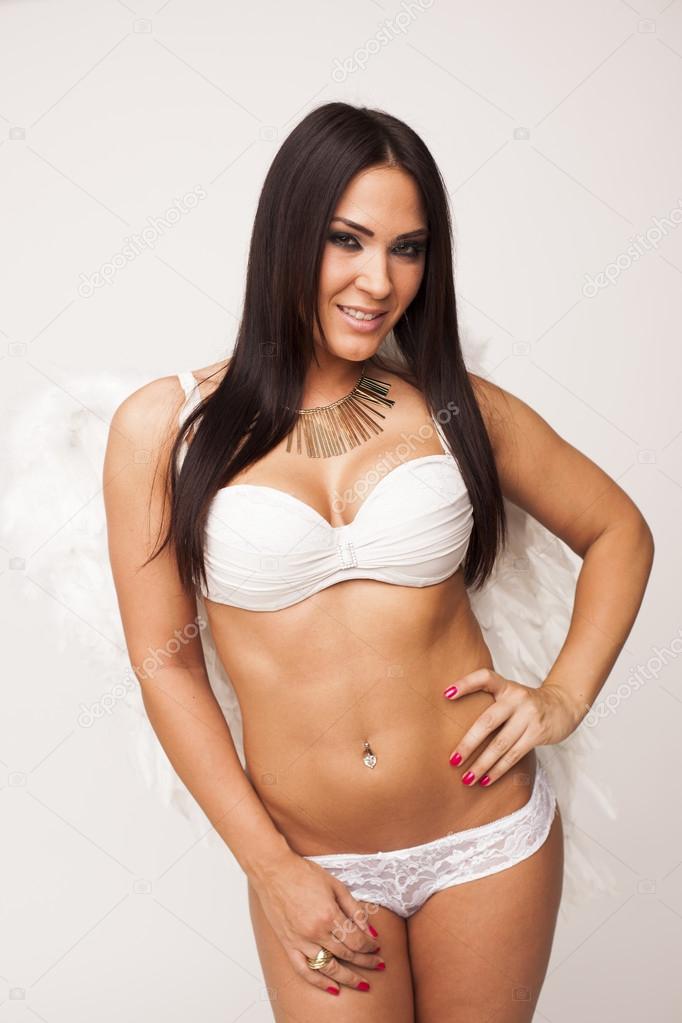Very sexy sensual brunette woman wearing angel wings on white isolated background