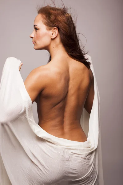 完璧なボディとセクシーなブルネットの女性は灰色の背景は分離に白い透明な繊維で覆われています。 — ストック写真