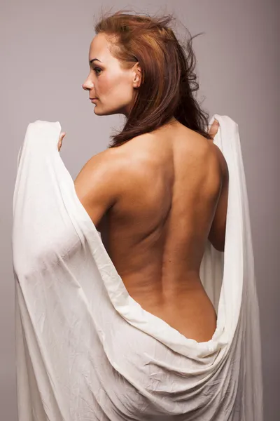 완벽 한 시체와 함께 섹시 갈색 머리 여자 고립 된 회색 배경에 흰색 투명 한 직물으로 덮여 — 스톡 사진