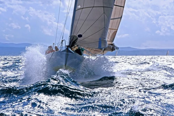 Sailboat breaking through the splashing wave — Stock Photo, Image