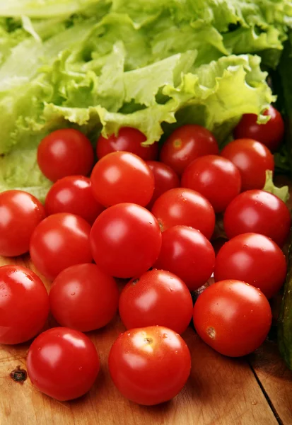 Tomates cerises rouges sur une planche en bois — Photo