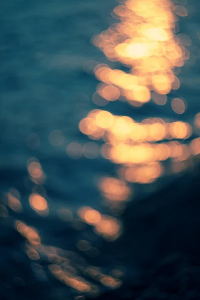 Luces doradas sobre fondo de agua azul . —  Fotos de Stock