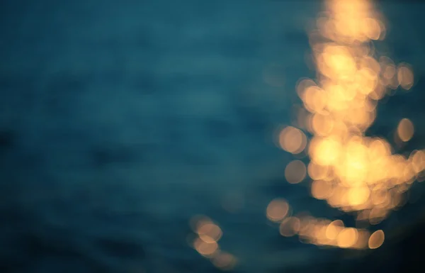 Luces doradas sobre fondo de agua azul . — Foto de Stock