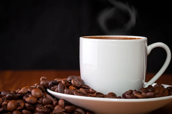 Cup of coffee against dark background — Stock Photo, Image