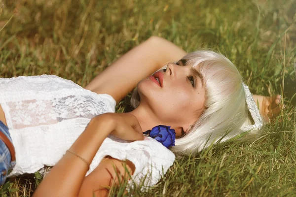 La hermosa rubia tumbada en la hierba — Foto de Stock