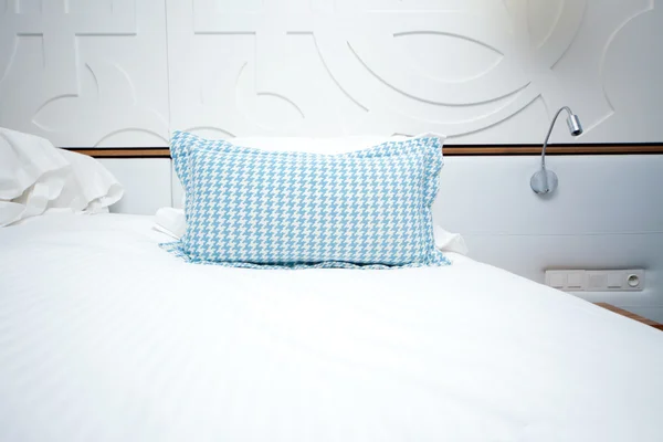 Image d'un lit avec oreiller bleu dans la chambre d'hôtel — Photo