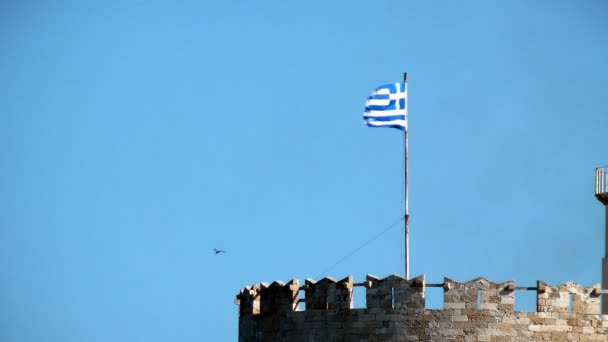 Die griechische Nationalflagge auf einem Himmelshintergrund. Rhodos-Festung. Griechenland. — Stockvideo