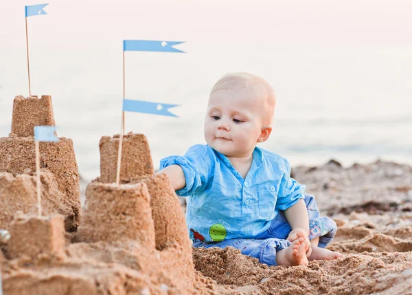 Cute boy playing with sand on beach — Stock Photo, Image