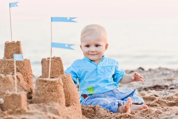 Cute boy playing with sand on beach — Stock Photo, Image