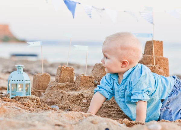 Schattige jongen spelen met zand op het strand — Stockfoto