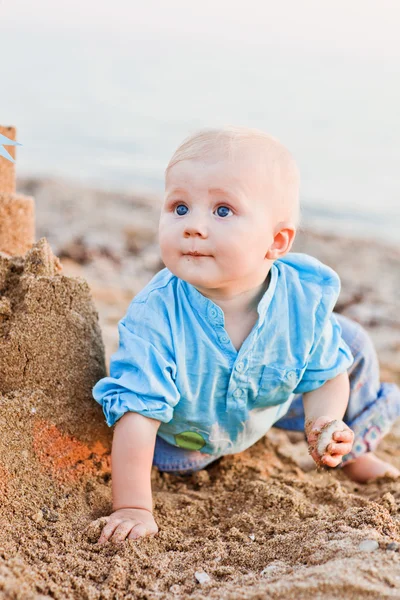 Roztomilý chlapec hraní s pískem na pláži — Stock fotografie