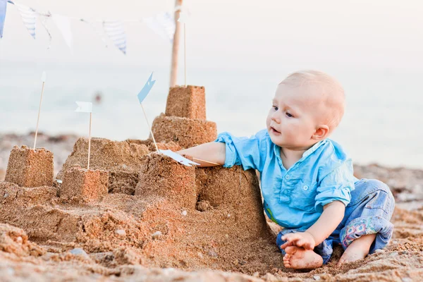 Roztomilý chlapec hraní s pískem na pláži — Stock fotografie