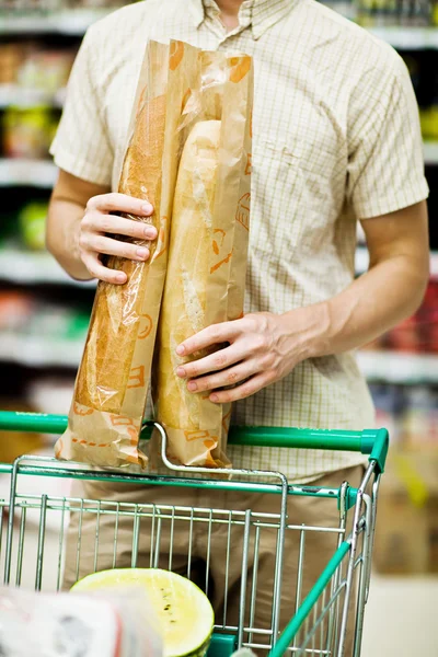 Hombre sosteniendo bolsa de compras con pan — Foto de Stock