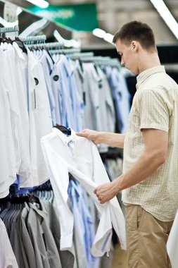 genç adam giyim mağazasında seçer.