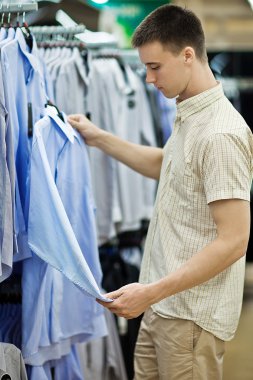 genç adam giyim mağazasında seçer.
