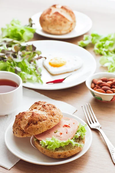 Colazione con hamburger, tè, uova e insalata verde — Foto Stock