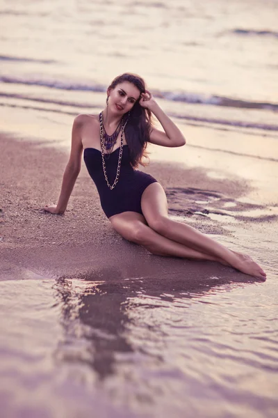 Belle femme posant sur la plage au coucher du soleil — Photo