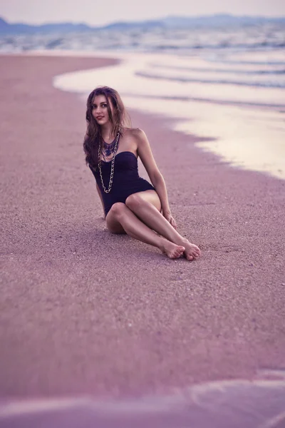 Belle femme posant sur la plage au coucher du soleil — Photo