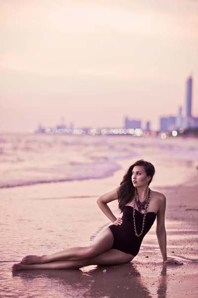 Όμορφη γυναίκα που θέτουν στην παραλία στο ηλιοβασίλεμα — Φωτογραφία Αρχείου