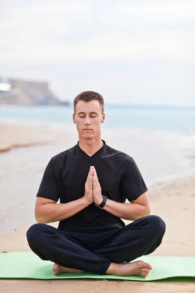 Joven haciendo yoga en la playa — Foto de Stock