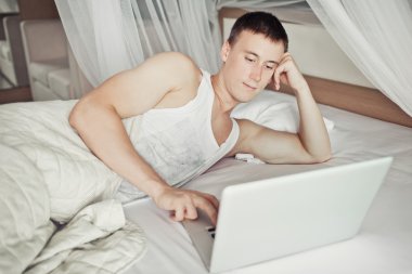 yatakta onun laptop ile yatan adam