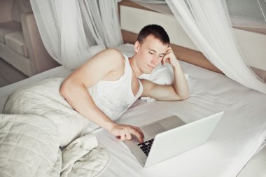 yatakta onun laptop ile yatan adam