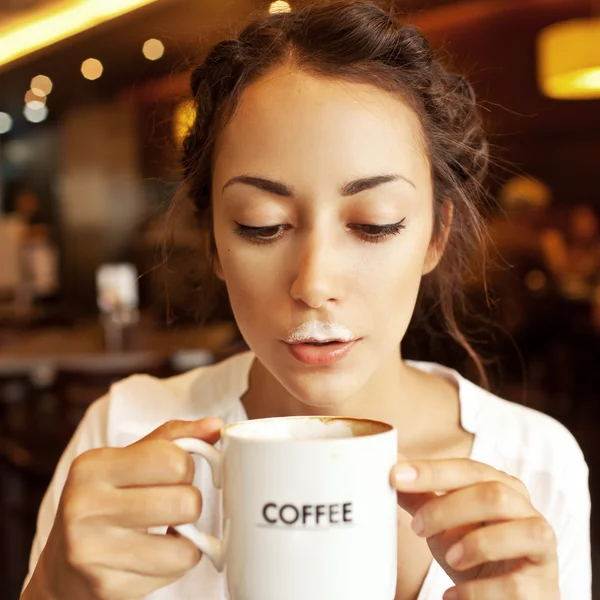 Funny woman with foam from coffee in cafe — Stock Photo, Image