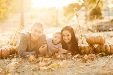 mutlu bir aile ile kabak üzerinde sonbahar yaprakları. Açık.
