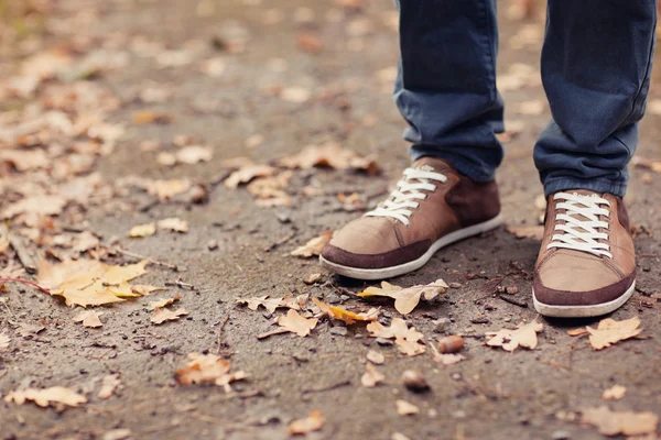 Ein Mann, der allein im Herbst durch den Wald spaziert — Stockfoto