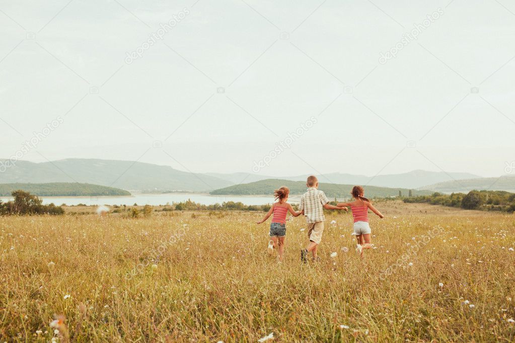 Children on a beautiful sunlit meadow in autumn