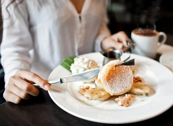 Woman eating pancakes in a cafe — Stockfoto