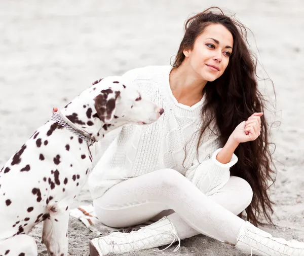 Kumsalda köpeği olan genç bir kadın. — Stok fotoğraf