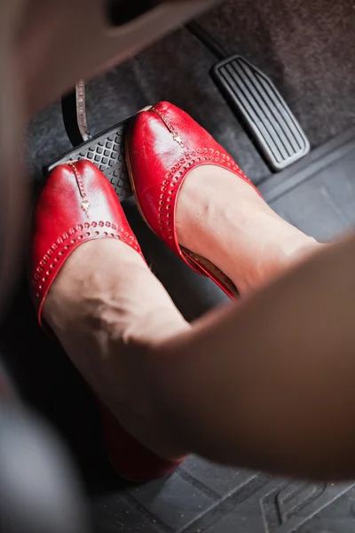 O pé de uma mulher pressionando o pedal do freio de um carro . — Fotografia de Stock