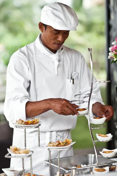Asian chef laying a table with luxury food and drinks on wedding. — Stock Photo, Image