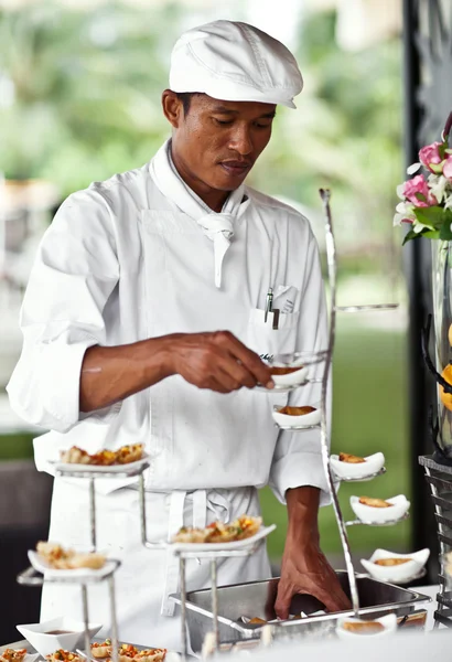 Asian chef laying a table with luxury food and drinks on wedding. — Stock Photo, Image