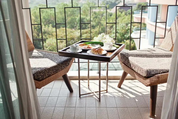 Ontbijt met kopje zwarte koffie, eieren en croissants op balkon — Stockfoto