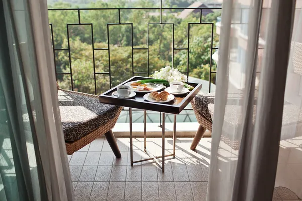Ontbijt met kopje zwarte koffie, eieren en croissants op balkon — Stockfoto