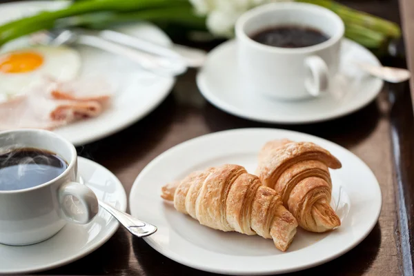 Frühstück mit schwarzem Kaffee, Eiern und Croissants auf dem Balkon — Stockfoto