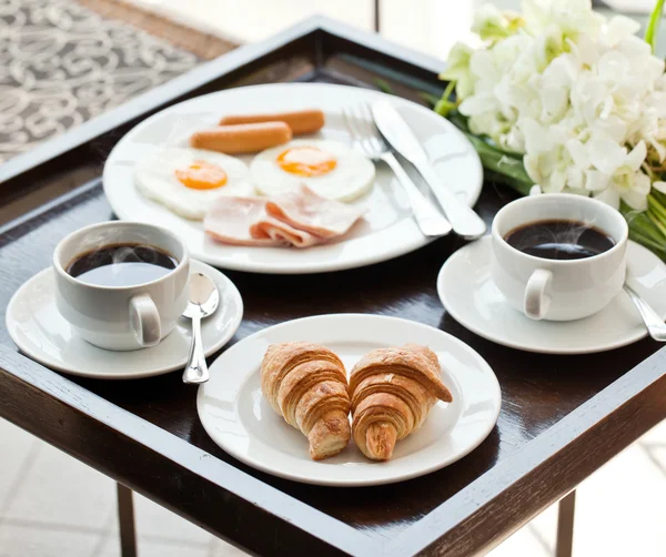 Frühstück mit schwarzem Kaffee, Eiern und Croissants auf dem Balkon — Stockfoto