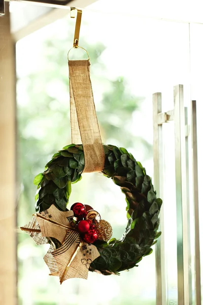 Corona de Navidad en la puerta de cristal en la tienda . — Foto de Stock