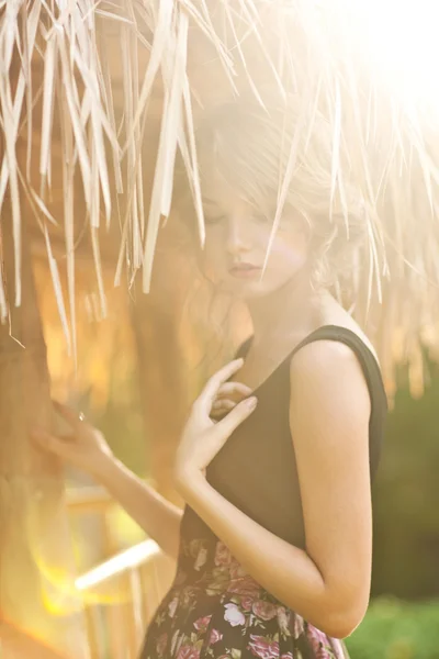 Outdoor portrait of beautiful young woman against sun — Stock Photo, Image