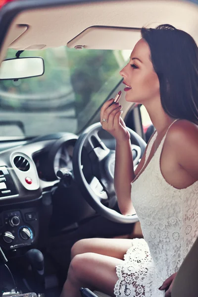 Piękna kobieta robi makijaż w samochodzie — Zdjęcie stockowe