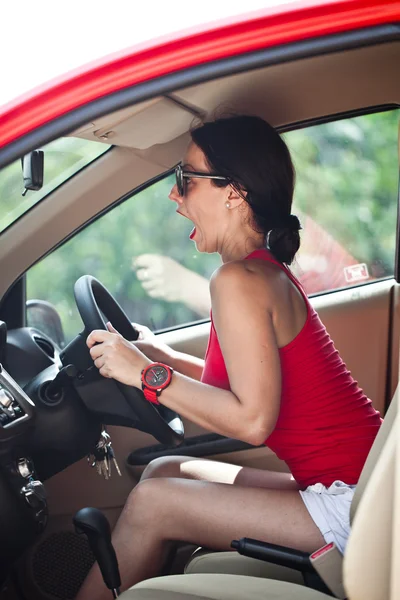 Krásná žena panika v červené auto — Stock fotografie