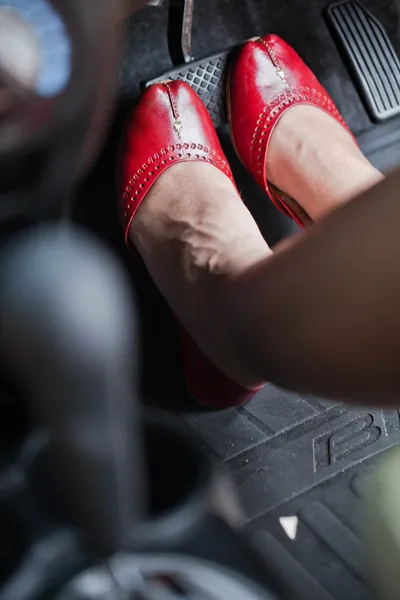 O pé de uma mulher pressionando o pedal do freio de um carro . — Fotografia de Stock