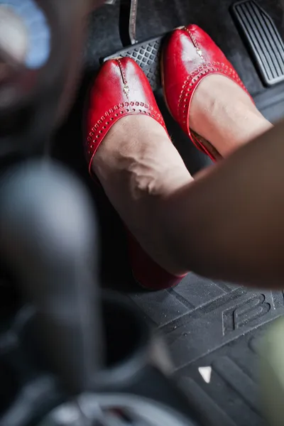 Een vrouw voet deprimerend het rempedaal van een auto. — Stockfoto