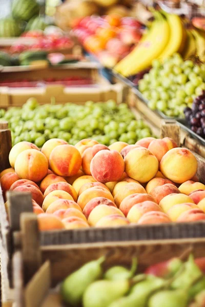 Различные свежие фрукты в коробках на рынке — стоковое фото