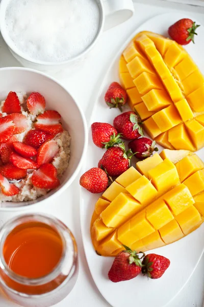 Gesundes Frühstück mit Mango, Erdbeere, Honig und Müsli — Stockfoto