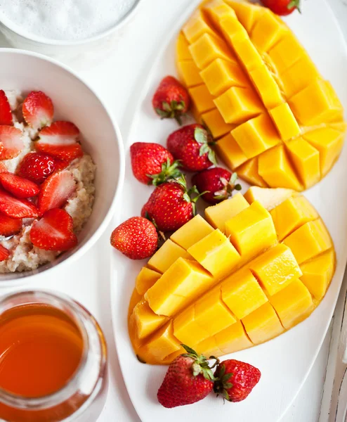 Gesundes Frühstück mit Mango, Erdbeere, Honig und Müsli — Stockfoto