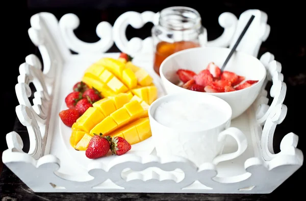 Здоровый завтрак с манго, клубникой, медом и хлопьями — стоковое фото